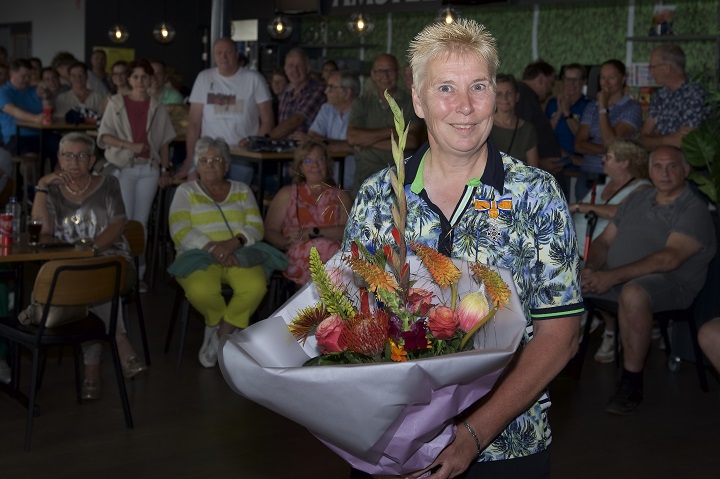 Mevrouw Willemien van de Wetering neemt bloemen in ontvangst